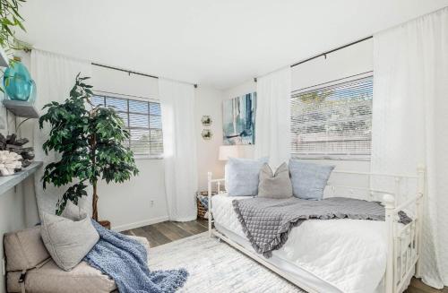 1 dormitorio con cama blanca y ventana en Bluewater Breeze en Satellite Beach