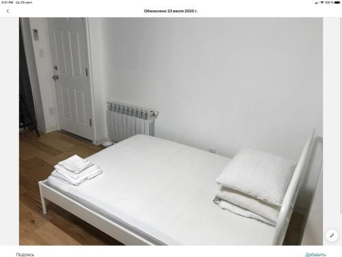a white bed in a room with towels on it at Brooklyn Beach Location in Brooklyn