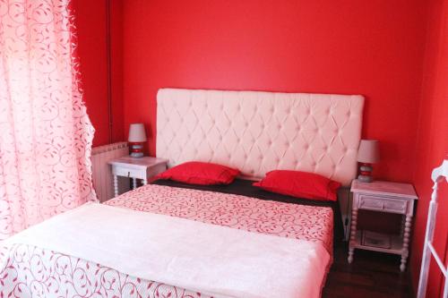 a red bedroom with a white bed with red pillows at Alojamento Local S. Bartolomeu in Trancoso
