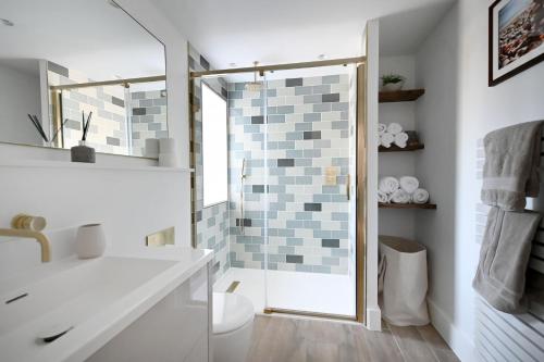 La salle de bains est pourvue d'une douche, de toilettes et d'un lavabo. dans l'établissement The Old Cottage Bakery, à Lyme Regis