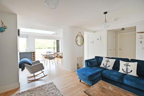 a living room with a blue couch and a table at The Old Cottage Bakery in Lyme Regis