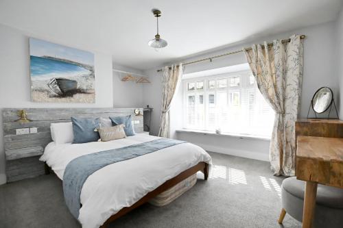 萊姆里吉斯的住宿－The Old Cottage Bakery，一间卧室设有一张大床和一个窗户。