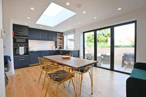 a kitchen with a wooden table and chairs in it at The Old Cottage Bakery in Lyme Regis
