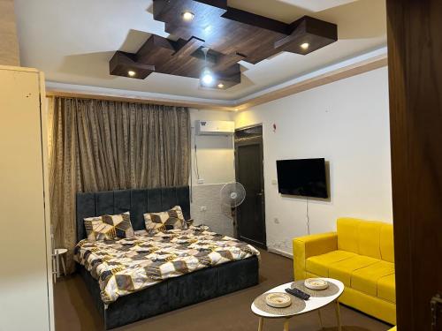 1 dormitorio con cama y sofá amarillo en Furnished Studio for rent, en Irbid