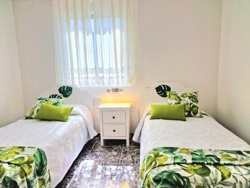 two beds in a small room with a window at Cozy House Casa de los Abuelos in Icod de los Vinos by in Icod de los Vinos