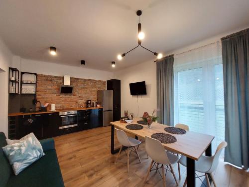 a dining room and living room with a table and chairs at Apartamenty Brenna Klimorówka in Brenna