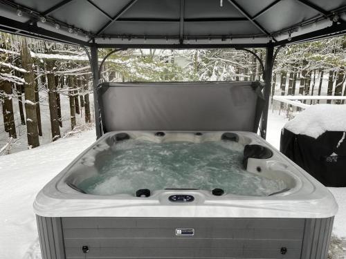 a hot tub in a gazebo in the snow at Cozy Cabin Inn in Owen Sound