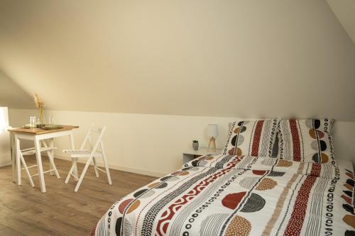 a bedroom with a bed and a table and a desk at TC Residences - Charmant Appartement in Saint-Quentin