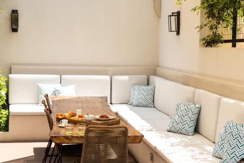 a table and chairs with a couch on a patio at Iris Skiathos in Skiathos Town