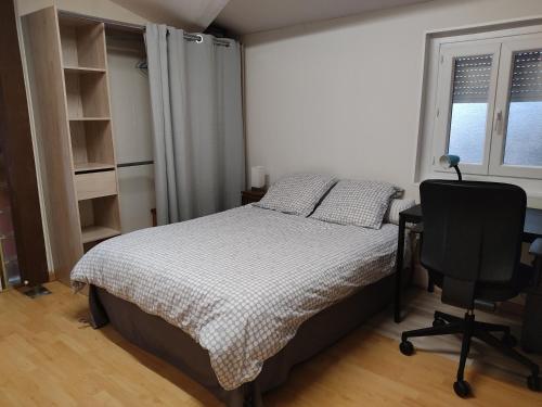 une chambre avec un lit, un bureau et une chaise dans l'établissement Maisonnette avec piscine près de la gare Part Dieu, à Villeurbanne