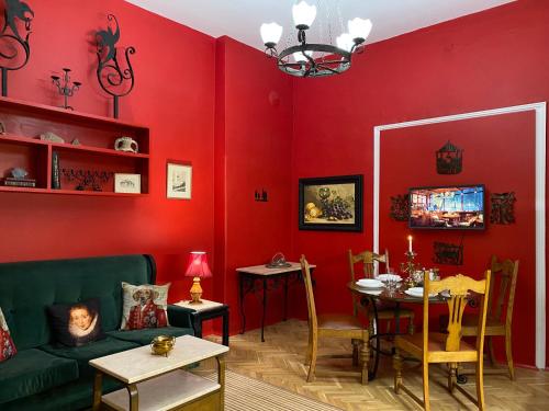 - un salon avec des murs rouges et un canapé vert dans l'établissement Plovdiv Central Vintage Apartment & Parking, à Plovdiv