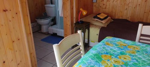 une chambre avec un lit, une table et des chaises dans l'établissement Maisonnette avec piscine près de la gare Part Dieu, à Villeurbanne