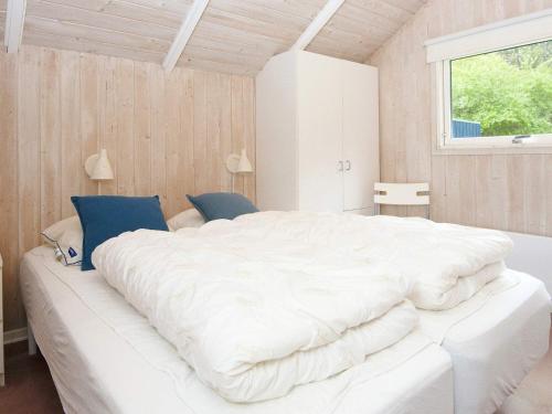 Cette chambre comprend un grand lit blanc et une fenêtre. dans l'établissement Holiday home Fårvang VII, à Fårvang