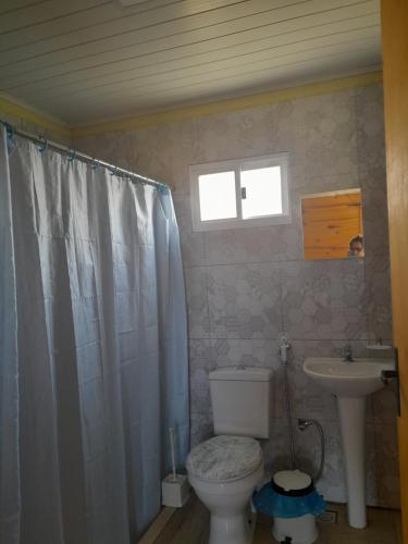 y baño con aseo y lavamanos. en Cabaña Gabon, en Barra del Chuy