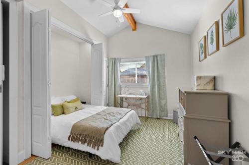 a white bedroom with a bed and a window at Game On Fayetteville's Premiere Entertainment-Packed Getaway in Fayetteville