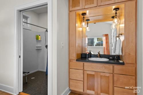 W łazience znajduje się umywalka i lustro. w obiekcie Game On Fayetteville's Premiere Entertainment-Packed Getaway w mieście Fayetteville