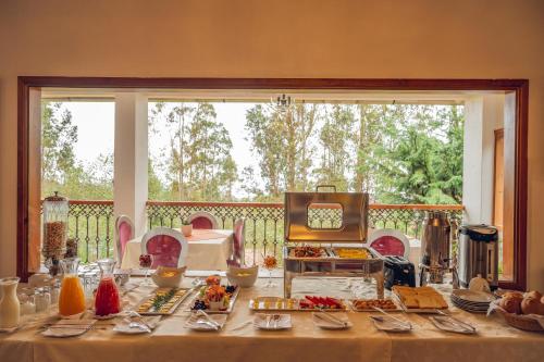 una mesa con comida en ella con una gran ventana en La Ensenada Hotel Chachapoyas, en Chachapoyas