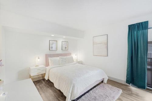 Dormitorio blanco con cama y cortina azul en LUXE Exclusive Studio: Pool, games, near TMC & NRG, en Houston