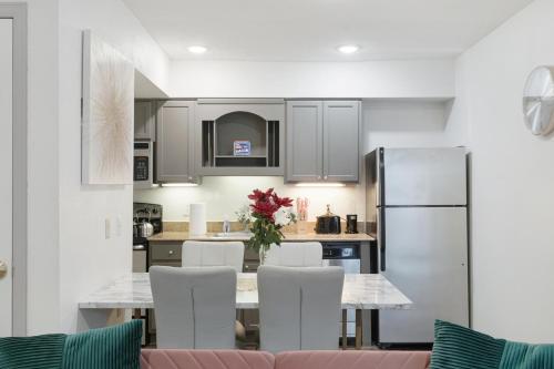 a kitchen with a table with white chairs and a refrigerator at LUXE Exclusive Studio: Pool, games, near TMC & NRG in Houston