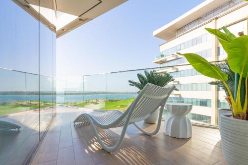 a balcony with two chairs and a large window at Paradise Holiday Home with Private Beach Access 605B2 in Abu Dhabi