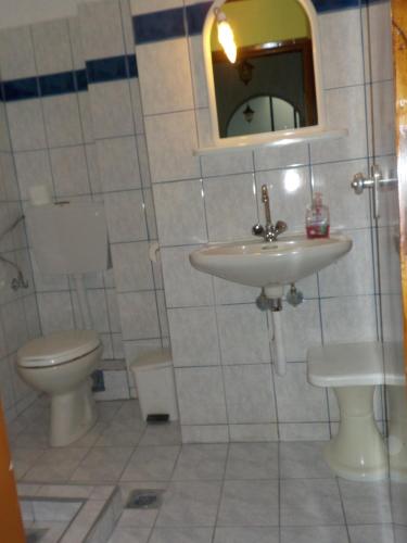 a bathroom with a toilet and a sink and a mirror at Hotel Prinos in Prinos