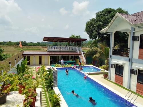 einen Pool in einem Resort mit Leuten darin in der Unterkunft Duran Pool & Guesthouse in Sison