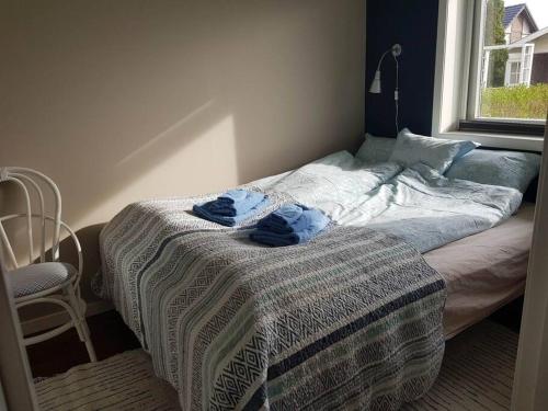 a bed in a bedroom with two blue towels on it at Leilighet i enebolig på Valderøya ved Ålesund in Ytterland