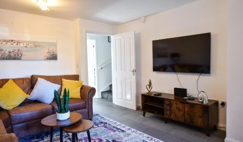 uma sala de estar com um sofá e uma televisão de ecrã plano em 3 Bedroom House close to city centre em Liverpool