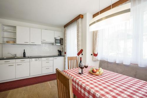 uma cozinha com uma mesa com uma taça de fruta em Apartment Romana em Selva di Val Gardena
