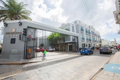 a city street with cars parked in front of buildings at Hotel Nacional Merida in Mérida
