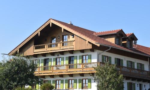 ein Gebäude mit Holzbalkonen darüber in der Unterkunft Ferienwohnung beim Hainz in Dietramszell