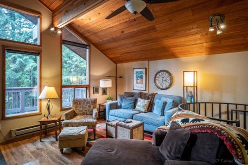 a living room with a blue couch and a table at Escape To Ptarmigan Village 86 in Whitefish