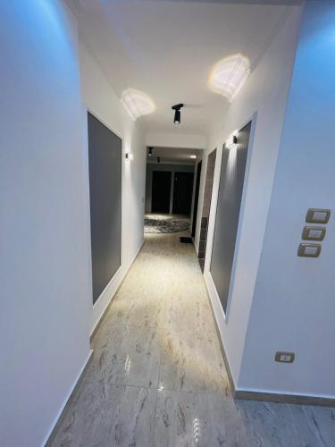 un corridoio in un edificio con pareti bianche e pavimenti in legno di شقق فندقيه a Il Cairo