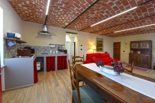 Il comprend une cuisine et un salon avec un canapé rouge. dans l'établissement Casa Valentina 1902, à Montegrosso dʼAsti