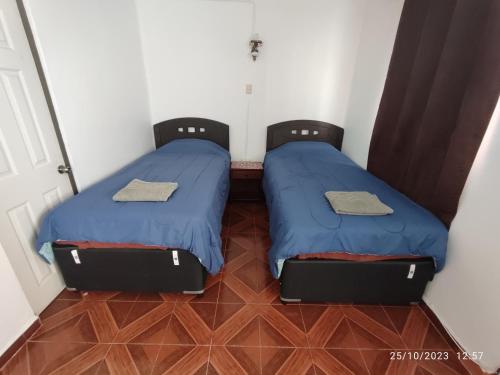 two beds sitting next to each other in a room at Departamento monoambiente centrico in Arica