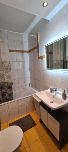City Wohnung 3 Zimmer في بريمين: حمام مع حوض وحوض استحمام ومرحاض