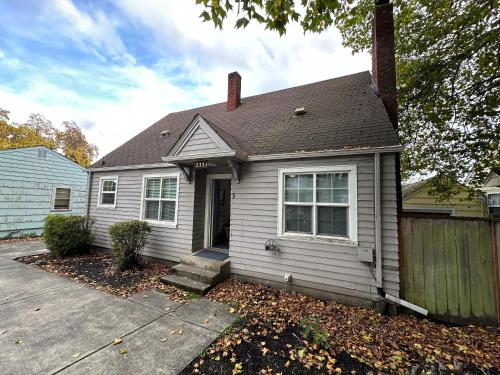 a white house with a porch and a fence at Charming 1930s Style Rustic Home in Eugene