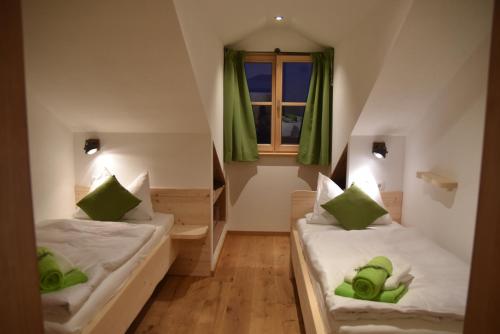 two beds in a small room with green pillows at Ferienwohnung beim Hainz in Dietramszell