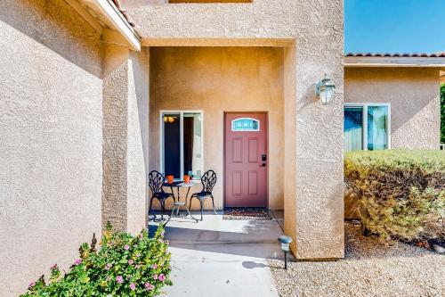 a pink door on a house with a table and chairs at Golf Paradise at Mission Lakes in Desert Hot Springs
