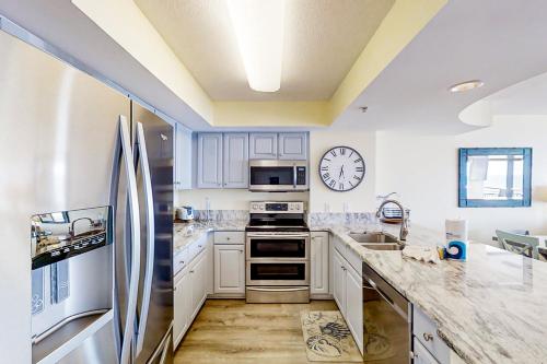 a kitchen with stainless steel appliances and a clock on the wall at Beachwalk Villas 504 in Myrtle Beach