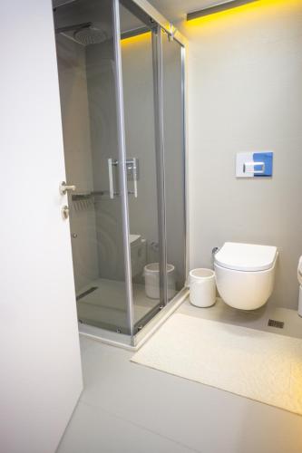 a bathroom with a toilet and a glass shower at Downtown Oasis - Spacious Modern 3-BR Flat near Beachpark in Antalya
