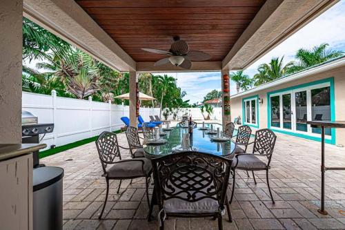 een patio met een tafel en stoelen en een plafondventilator bij Beach Paradise * 5 mins walk to beach *chef kitchen *private pool in Riviera Beach