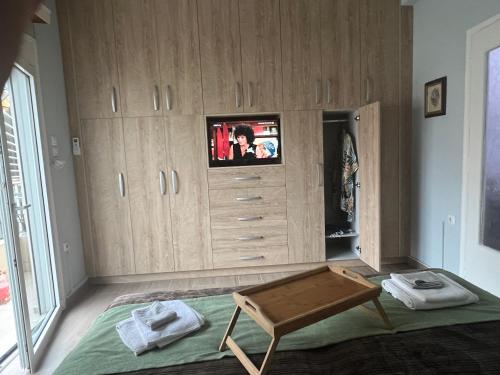 a living room with a tv on top of wooden cabinets at Rania's House in Piraeus
