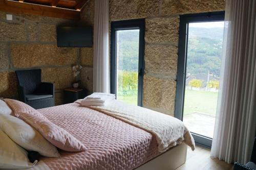 1 dormitorio con cama y ventana grande en O Palheiro da Anastácia en Marco de Canavezes