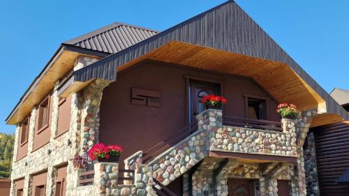 a building with flowers on the balcony of it at Stone Lodge 3 in Kolašin