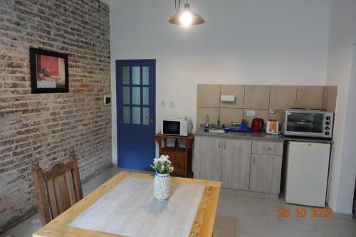 une cuisine avec une table en bois et une porte bleue dans l'établissement Pipí Cucú - Apartamentos Completos, à Crespo