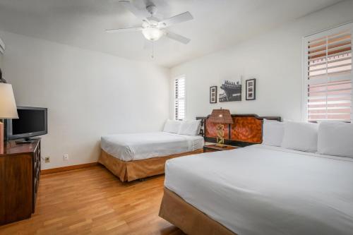 a bedroom with two beds and a flat screen tv at Shores at Waikoloa 224 - MCH in Waikoloa