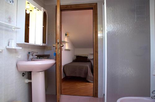 un bagno con lavandino e un letto in una camera di Hotel Anna a Fetovaia