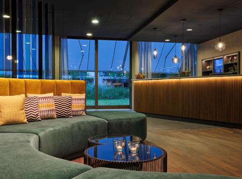 - un hall avec des canapés et une table avec des verres dans l'établissement Essential by Dorint Basel City, à Bâle