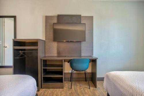 a desk with a blue chair in a room with two beds at Motel 6-Kingman, AZ - Route 66 East in Kingman